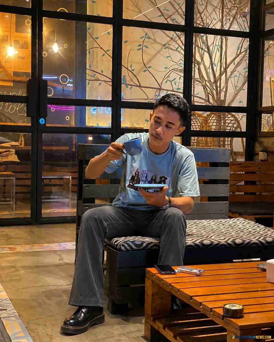 Pria menikmati kopi di kafe sebagai ilustrasi manfaat minum kopi setiap hari bagi kesehatan tubuh dan fokus otak.